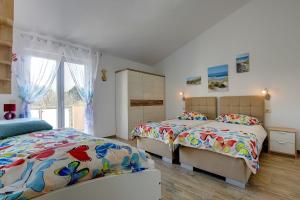 sypialnia z dwoma łóżkami i oknem w obiekcie Holiday Home Veronika w mieście Vinkuran