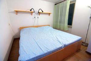 une petite chambre avec un lit avec des draps bleus dans l'établissement Apartment Bursic, à Pula