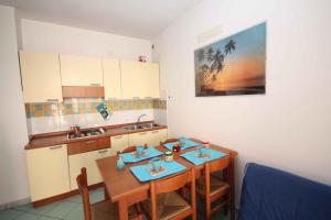 a kitchen with two wooden tables and a sink at Apartments in Rosolina Mare 24858 in Rosapineta