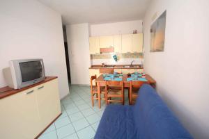 a kitchen with a table and a blue couch in a room at Apartments in Rosolina Mare 24858 in Rosapineta