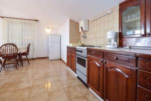 a kitchen with wooden cabinets and a white refrigerator at Apartment in Premantura/Istrien 10820 in Premantura
