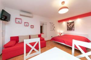 - une chambre avec un lit rouge et un canapé rouge dans l'établissement Studio Apartment in Vrsar I, à Vrsar