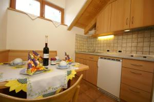 a kitchen with a table with a bottle of wine at Agriturismo La Flu in San Martino in Badia