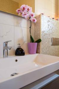 a white sink with a vase with a flower on it at Two-Bedroom Apartment in Okrug Gornji III in Trogir