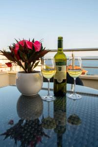 a table with two wine glasses and a bottle of wine at Two-Bedroom Apartment in Okrug Gornji III in Trogir