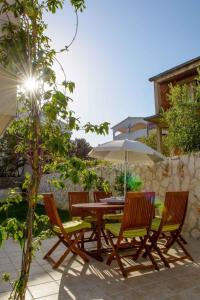 a wooden table and chairs with an umbrella at Two-Bedroom Apartment in Okrug Gornji III in Trogir