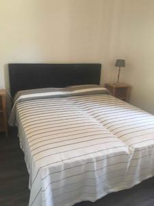 a large bed in a bedroom with a black headboard at Apartments in Pur/Ledrosee 22640 in Mezzolago