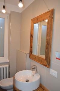 y baño con lavabo, espejo y aseo. en Apartments in Pur/Ledrosee 22640 en Mezzolago