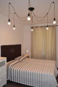 a bedroom with a large bed with lights above it at Apartments in Pur/Ledrosee 22640 in Mezzolago