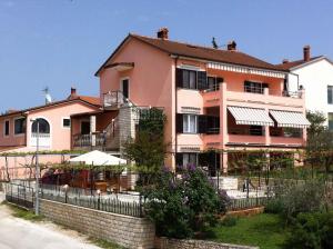 a pink building with a fence in front of it at Apartment in Pula/Istrien 17385 in Veli Vrh