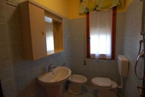 La salle de bains est pourvue d'un lavabo, de toilettes et d'un miroir. dans l'établissement Rosolina Mare Apartment 5, à Rosolina Mare