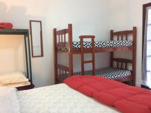 Un dormitorio con 2 literas y una almohada roja en una cama en Piccolo Borgo Antico - Casina delle Rondini, en Campos do Jordão