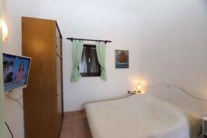 a room with a bed and a television and a window at Studio in Silo/Insel Krk 14757 in Šilo