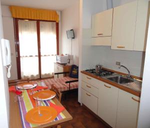 una piccola cucina con tavolo e piatti di Apartments in Bibione 24565 a Bibione
