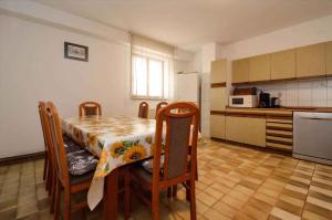 a kitchen with a table and chairs and a refrigerator at Apartment in Pula/Istrien 17325 in Vintijan