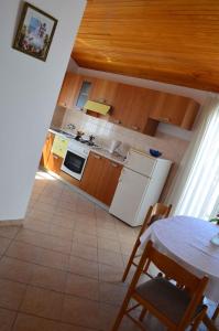 a kitchen with a table and a white refrigerator at Palit Apartment 1 in Palit