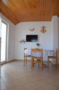a dining room with a table and chairs and a tv at Palit Apartment 1 in Palit