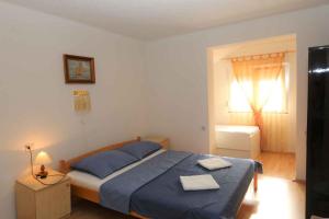 a bedroom with a bed with blue sheets and a window at Silo Apartment 17 in Šilo