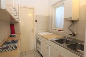 małą kuchnię ze zlewem i oknem w obiekcie Silo Apartment 17 w mieście Šilo