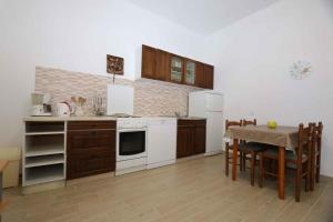 a kitchen with white appliances and a table with chairs at Apartment Silo 19 in Šilo