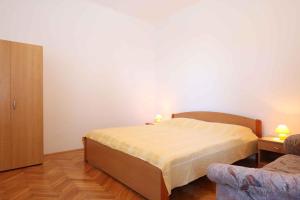 a small bedroom with a bed and a chair at Apartment Silo 19 in Šilo