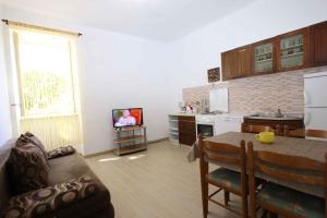 a living room with a kitchen with a table and a television at Apartment Silo 19 in Šilo