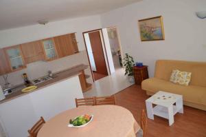a kitchen and a living room with a table and a couch at Palit Apartment 2 in Palit