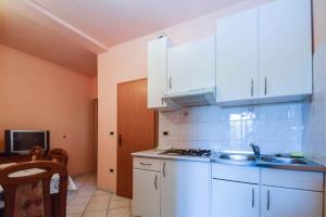 a kitchen with white cabinets and a sink in it at Apartments in Pjescana Uvala/Istrien 10996 in Pješčana Uvala