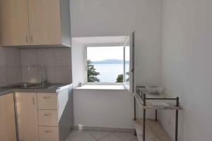 a kitchen with a window with a view of the ocean at Biograd na Moru Apartment 1 in Biograd na Moru