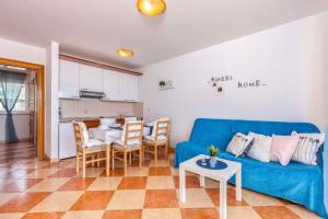 a living room with a blue couch and a table at Crikvenica Apartment 21 in Dramalj