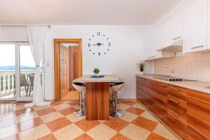 a kitchen with a table and a clock on the wall at Apartment in Dramalj 5715 in Dramalj