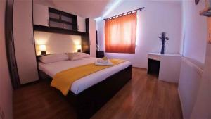 a bedroom with a bed with a yellow blanket on it at Apartment in Vodice 7702 in Vodice