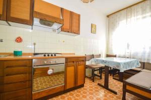 a kitchen with a stove and a table in it at Two-Bedroom Apartment in Pula IX in Veruda