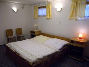 1 dormitorio con 1 cama, 2 mesas y 1 vela en Apartment Balatonbereny 1 en Balatonberény