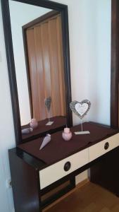 komodę z lustrem i różowymi przedmiotami w obiekcie Apartment Bribir 3 w mieście Kričina