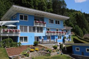 a blue house with flowers in front of it at Flattach Apartment 4 in Ausserfragant