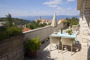 a patio with a table and chairs on a balcony at Apartment Vrbnik 6 in Vrbnik