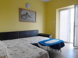 a bedroom with two beds and a table in it at Apartment Lopar 13 in Lopar