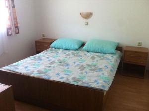 a bed with two blue pillows in a bedroom at Apartment Lopar 3 in Lopar