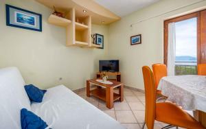 Zimmer mit einem Bett, einem Tisch und einem TV in der Unterkunft Apartment Drenje 4 in Drenje