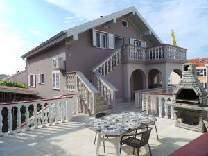 a house with a patio with a table in front of it at Apartment Crikvenica, Vinodol 8 in Crikvenica