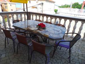 una mesa con sillas y una mesa con rosas en el balcón. en Apartment Crikvenica, Vinodol 8, en Crikvenica