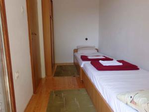 a small room with two beds with red towels on them at Apartment Sv. Marina 1 in Sveta Marina