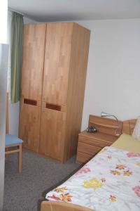 Schlafzimmer mit einem Bett und einem Holzschrank in der Unterkunft Apartment Todtmoos 3 in Vordertodtmoos