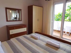 a bedroom with a bed and a dresser and a window at Apartment Ljubac 1 in Ljubač