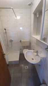 ein weißes Bad mit einem Waschbecken und einem WC in der Unterkunft Apartment Ljubac 1 in Krneša