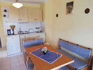 ザラカロシュにあるApartment Zalakaros 3のキッチン(木製テーブル、青い椅子付)、キッチン(冷蔵庫付)