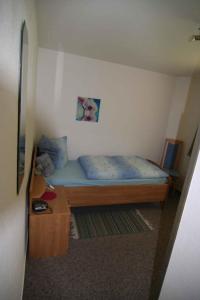 ein kleines Schlafzimmer mit einem Bett und einem Tisch in der Unterkunft Apartment Todtmoos 2 in Todtmoos