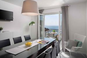 a dining room with a table and a view of the ocean at Apartment Rabac 11 in Rabac