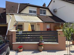 a house with a fence and a yellow umbrella at Apartment in Balatonkenese - Balaton 18978 in Balatonkenese